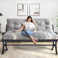 a woman sitting on top of a futon couch