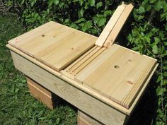 a wooden box sitting on top of a lush green field