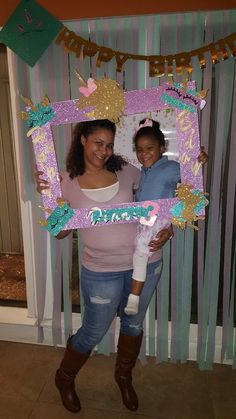 two women standing in front of a photo frame