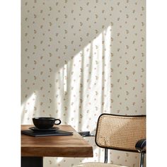 a wooden table with a black bowl on top of it next to a wall paper