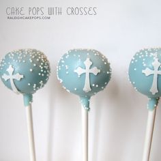 three blue cake pops with crosses on them