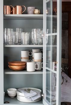 the shelves are filled with dishes and cups