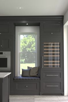 a kitchen with gray cabinets and a window seat