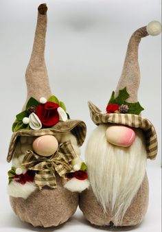 two gnomes with hats and bows on their heads