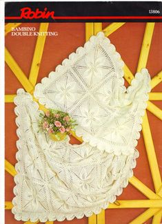 an old knitting book with white crocheted doily and flowers on the cover