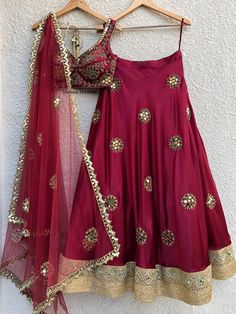 This glamorous crimson lehenga is hand embellished on lush satin with mirror work, cutdaana and swarovski stone details with borders at the hem.  It is teamed with a katori cut blouse and a tulle dupatta with border and buti details. Cultural Clothes, Bhumika Sharma, Pearls Embroidery, Orang India, Ethnic Wears, Desi Vibes, Blouse Works, Mirror Work Lehenga, Wedding Wardrobe