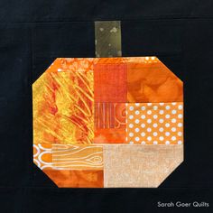 an orange patchwork pumpkin with white polka dots on it's black back ground