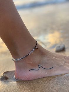 a woman's foot with a small wave tattoo on the side of her ankle