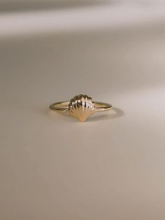 Inspired by Venus, the goddess of love, to celebrate love and relationships. First handcrafted from wax and then cast in gold, this ring's design echoes the delicate curves of a seashell, capturing the essence of Venus’s oceanic origins. Each piece honors the beauty and harmony of nature, making it a perfect symbol of romance and new beginnings. A must-have for your jewelry collection. Shell measures approximately 8 mm. Band thickness is 1.3 mm. Shiny finish or matte finish. Made with 10K solid yellow or white gold. Shell Engagement Ring, Handmade Delicate 14k Gold Rings, Delicate Handmade 14k Gold Rings, 14k Gold Pearl Promise Ring, Handmade 14k Yellow Gold Midi Rings, 14k Gold Hand Forged Promise Ring, Hand Forged 14k Gold Engraved Promise Ring, Hand Forged Recycled Gold Dainty Rings, Gold 14k Pearl Promise Ring