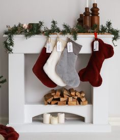 stockings hanging from a fireplace with candles and christmas decorations