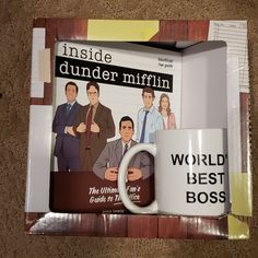 the office coffee mug is next to an inside dunder mifflin magazine cover