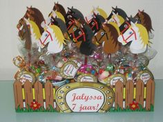 there are many horses on top of the candy box stand together in front of a white wall