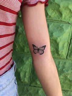 a small butterfly tattoo on the arm