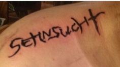 a person with a tattoo on their shoulder that says, steinuht in black ink