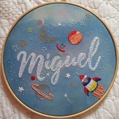 an embroidered wall hanging with space and stars on it