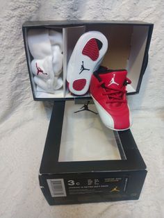 Infant toddler gift pack baby cap hat and shoes are in excellent condition worn a few times kept very clean Elevate your baby's shoe game with these iconic Jordan 12 Retro sneakers. Featuring a red, white, and black colorway and the famous Michael Jordan logo, these lace-up sneakers are perfect for any occasion, whether it's a casual day out or some light activity. Made of synthetic leather and foam, these shoes are durable and comfortable for your little one's feet. These sneakers are part of t Michael Jordan Logo, Infant Hat, Infant Shoes, Light Activities, Jordan Logo, Air Jordan 12, Toddler Gift, Air Jordan 12 Retro, Jordan 12 Retro