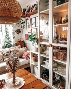 a living room filled with lots of furniture and plants on top of shelves in front of a window