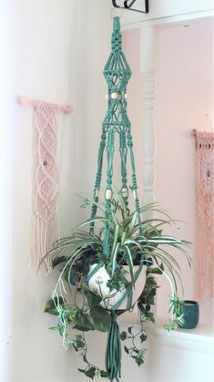 a potted plant hanging from the side of a wall with macrame beads