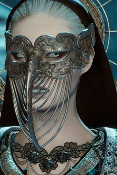 a woman wearing a silver mask and black hair