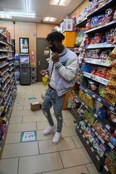 a man is walking through a grocery store while talking on his cell phone and wearing sunglasses