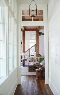 an open door leading to a living room with white walls and wood floors, along with a wooden floor