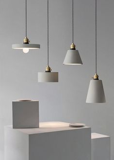 four white lamps hanging from the ceiling in a room