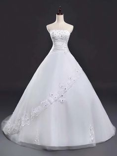 a white wedding dress on a mannequin with flowers and lace around the waist