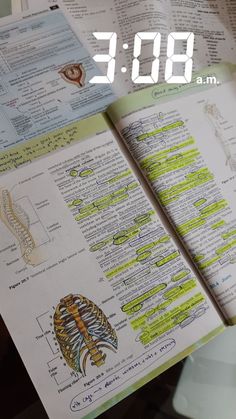 an open book with some drawings on it and the time displayed in front of it