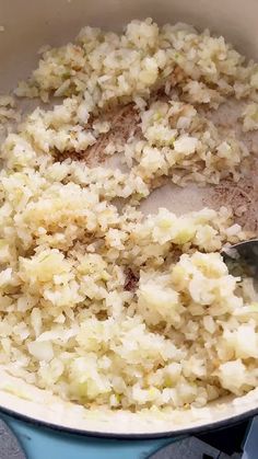 rice being cooked in a pot with a spoon