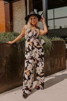 - Kick back and enjoy some vacay vibes in this stylish jumpsuit! - Unlined material with an abstract floral print - A v-cut neckline with a twist detail - Adjustable spaghetti straps - A smocked upper back with a tie detail - A wide legged jumpsuit with floor length hemlines Chic Printed Jumpsuits And Rompers For Vacation, Chic Printed Jumpsuit For Vacation, Chic Black Printed Jumpsuits And Rompers, Chic Floral Print Jumpsuits And Rompers For Beach, Chic Floral Print Beach Jumpsuit, Chic Beach Jumpsuit With Floral Print, Black Floral Print Jumpsuits And Rompers For Vacation, Black Floral Print Jumpsuit For Vacation, Wide Legged Jumpsuit