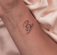 a woman's arm with a small tattoo on it