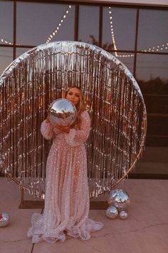 a woman in a pink dress holding a silver object