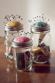 three mason jars with pins and needles in them