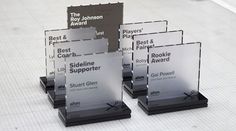 four clear award plaques sitting on top of each other in front of a white background