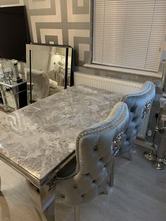 a marble dining table and chairs in a room with mirrored walls, flooring and furniture