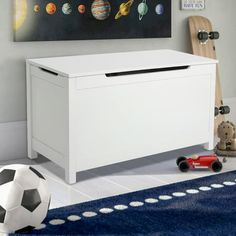 a toy chest in a child's room with space themed artwork on the wall