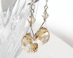 "Gorgeous bridesmaid dangle earrings are handmade with teardrop shaped and champagne hued Swarovski crystals. These teardrop earrings are the color of a very light yellow topaz stone or similar to a citrine gemstone. Long dangle earrings but the Swarovski crystal teardrop is not too big so it is just enough to complement any outfit. Perfect for weddings, dress up occasions and formals.  Earring Details: - Earring length with two chain links is 2.75 inches long - Champagne Swarovski teardrop crys Gold Briolette Crystal Earrings For Wedding, Faceted Crystal Earrings For Wedding, Faceted Teardrop Crystal Earrings For Wedding, Teardrop Faceted Crystal Earrings For Weddings, Formal Teardrop Citrine Earrings, Wedding Teardrop Faceted Crystal Earrings, Teardrop Citrine Earrings For Gift, Handmade Citrine Teardrop Earrings, Silver Citrine Drop Earrings Jewelry