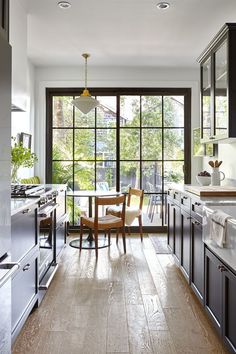 a kitchen with wooden floors and black cabinets