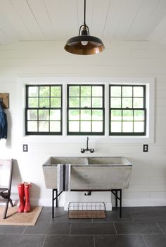 a bathroom with two windows and a sink in the center, along with a rug on the floor