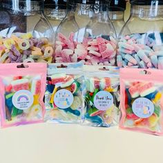 three bags filled with candy sitting on top of a table next to bottles and jars