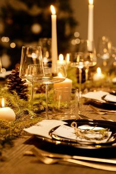 the table is set with wine glasses and candles