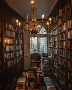 a chandelier hanging from the ceiling in a library filled with books