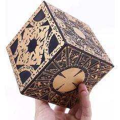 a hand holding up a wooden object with intricate designs on the outside and inside it