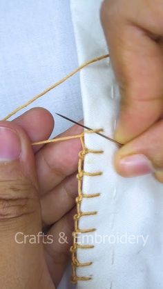 someone is working with some thread on a piece of cloth