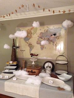 a table topped with lots of plates covered in white fluffy clouds next to a map