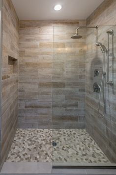 a walk in shower sitting inside of a bathroom next to a tiled wall and floor