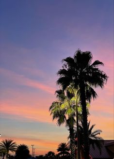 a palm tree is silhouetted against the sunset in this photo taken from an empty parking lot