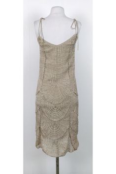 Take this stunning dress on your next vacation getaway. Made in a knit fabric with metallic threads that add a pop of shimmer. Style it with sandals and a sun hat. Size 6 60% cotton, 40% polyster V-neck Ties at straps Lined Metallic threads Slips on Tiny stain on back of dress Bust 31" Waist 30" Shoulder to hem 43.5" Beige Knit Crochet Summer Dress, Fitted Knit Dresses For Summer, Beige Knit Dress For Beach Season, Elegant Crochet Dress For Summer Vacation, Chic Crochet Dress For Summer Evenings, Knit Summer Vacation Dresses, Summer Knit Party Dress, Summer Party Knit Dress, Beach Beige Knit Dress