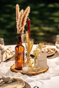 the table is set with wine bottles and place settings