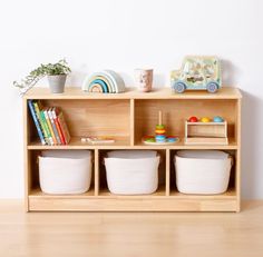 a wooden shelf with baskets and toys on it